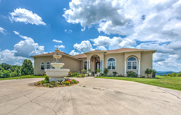 Tuscan style home with fountain out front and circle drive